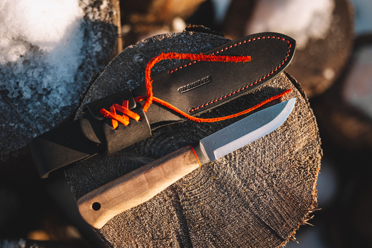 Knife with leather sheath on a wooden surface
