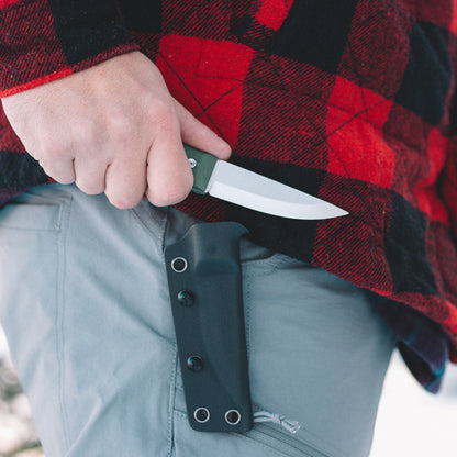 Person holding a knife with a sheath against a red and black checkered background