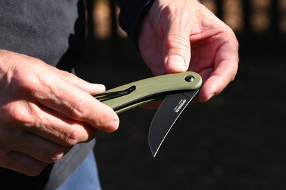 Person holding a folding knife with a blurred background
