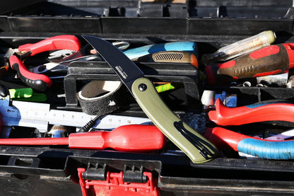 Assorted tools including a knife with a green handle in a toolbox.